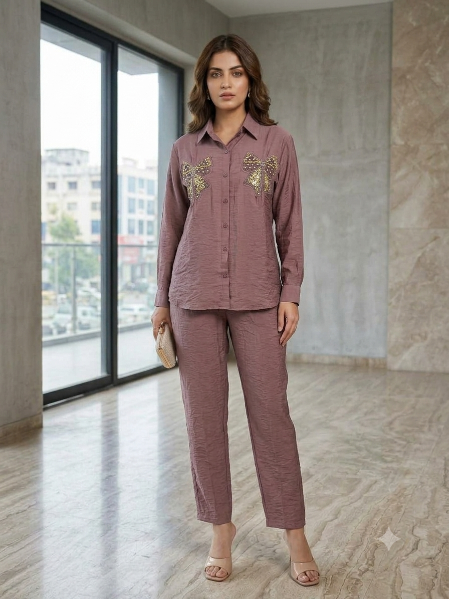 Front view of a dusty-rose button-front shirt with embellished bows and matching trousers